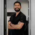 Portrait of a confident male dentist with arms crossed in a modern dental clinic.