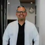 Smiling male dentist in modern dental office for healthy teeth and smile care.