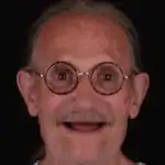 Close-up of smiling elderly man with glasses, showcasing healthy teeth at Molar House.