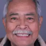 Close-up of friendly elderly man with bright smile, showing healthy teeth and confident expression.