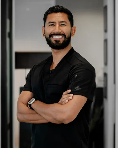 Portrait of a confident male dentist with arms crossed in a modern dental clinic.